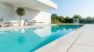 Well-maintained backyard swimming pool with loungers