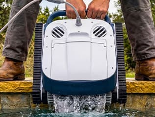 Family relaxing by a spotless backyard pool — are robotic pool cleaners worth it